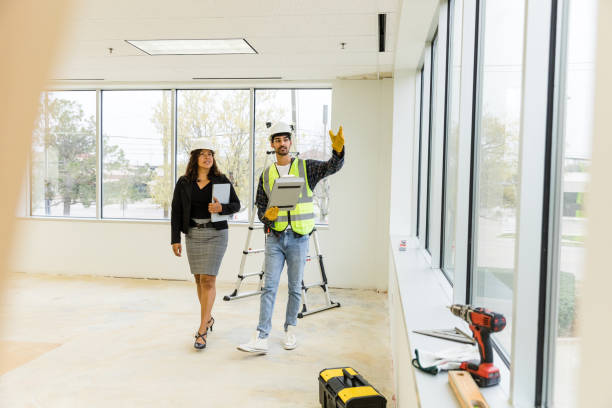 Foreman supervisor meets with the female city employee to confirm the timeline for the new building stock photo