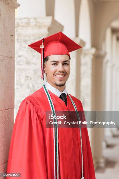 A 2023 Highschool Senior Young Man In A Red Graduation Cap Gown With Three Honors Tassels A Welldressed 18yearold Cubanamerican With Brown Hair Brown Eyes Looking Fresh Sharp In A Suit Tie In A Classy Location In Palm Beach Florida Stock Photo - Download Image Now