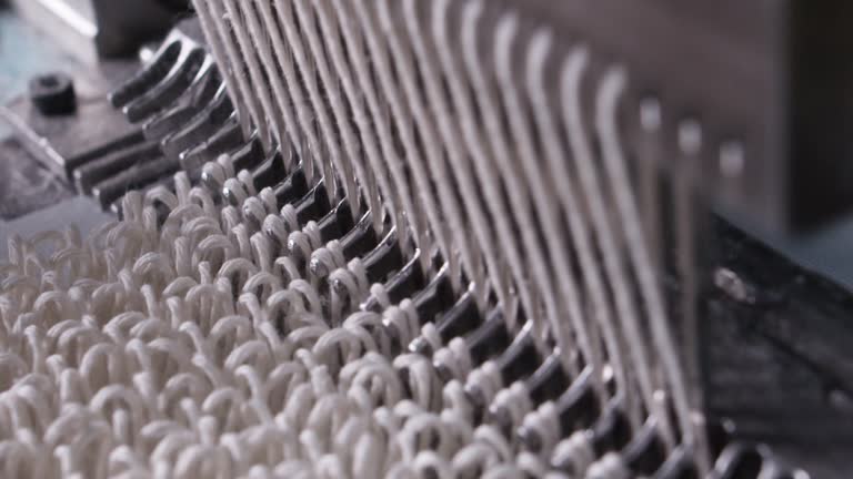 Closeup of weaving mechanism is fabricating synetic MOP