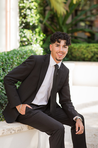 2023 High-School Senior Young Man Well-Dressed in a Black Suit, White Dress Shirt, Black Tie & Black Suede Shoes, An18-Year-Old Cuban-American with Brown Hair & Brown Eyes Looking Fresh & Sharp in a Suit & Tie in a Classy Location in Palm Beach, Florida