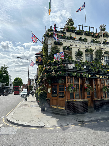 View of the outside of the Churchill Arms in London. Large amounts of flowers and UK decorations can be seen on the exterior. The Churchill Arms, the London's most famous pub. Scenic victorian pub in Notting Hill, Kensington. The London's most colourful pub.