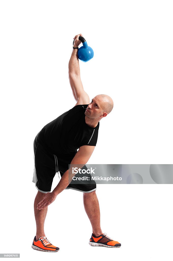 Człowiek w pracy z odważnikiem kettlebell - Zbiór zdjęć royalty-free (Białe tło)