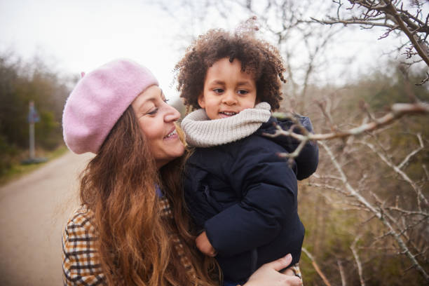 istock Smiling mom standing outside with her son in her arms during a walk 1490975737