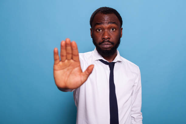 istock Serious looking businessman in white shirt doing hand stop in dissapproval 1490978499