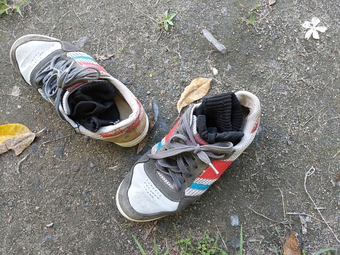 A pair of sport shoes, which are starting to fade with black socks