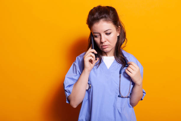 istock Medical assistant using smartphone to talk on phone call 1490983018