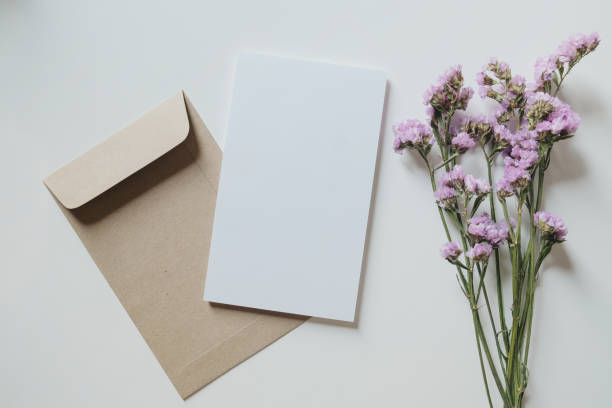 istock White blank greeting or invitation card and envelope with pink flowers decoration on white background. Mock up presentation. 1490983419