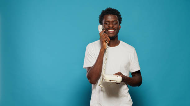 istock Young adult using landline telephone for phone call 1490985497