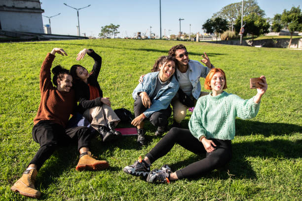 istock Young friends taking a selfie sitting on grass at public park 1490985708