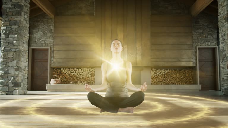 Beautiful Relaxed Caucasian Woman Meditating In Zenlike Openair Space. Animated Visualization Of Bright Energy Accumulating In Her Chest. Yoga Practice, Self-care, And Mindfulness Concept.