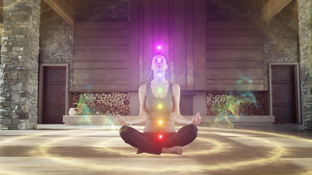 Beautiful Relaxed Caucasian Woman Meditating In Zenlike Openair Space. Animated Visualization Of Multi Colored Chakras Appearing On Her Body. Spirituality, Yoga, Self-care, Mindfulness Concept.