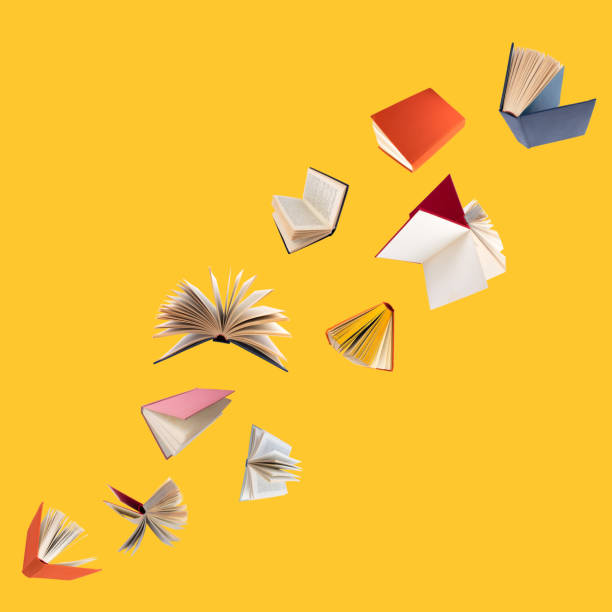 istock Colorful hardcover books flying isolated on yellow background. 1490986821