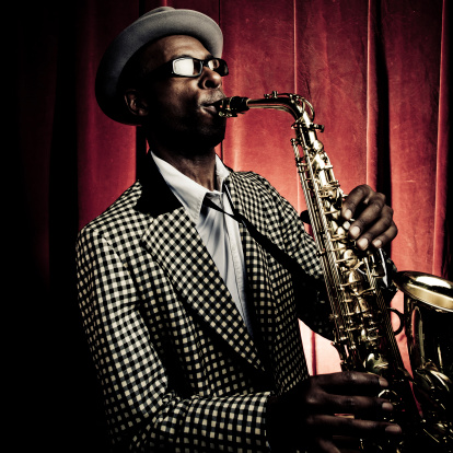 Man playing a saxophone and wearing sunglasses isolated on white background