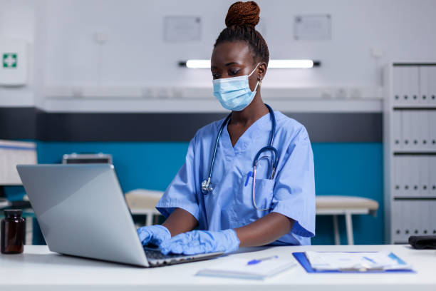 istock Black woman with nurse profession using modern laptop 1490994544