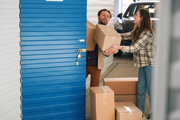 istock Young guy and lady with big cardboard boxes in self-storage unit 1491007290