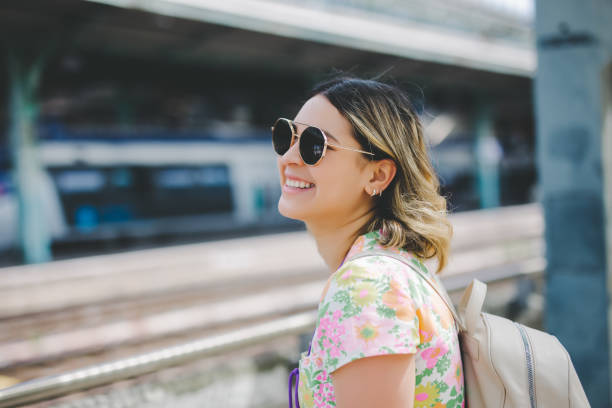 Happy young woman to the train station