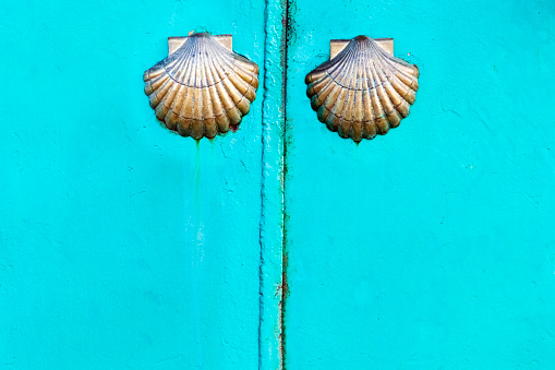 Scallops, camino de Santiago symbol on closed metal green door. Cambados, Rías Baixas, Pontevedra province, Galicia, Spain.