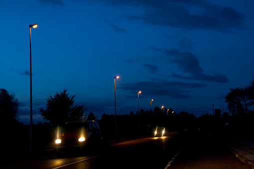 Road view at dusk, straight row of street lights, traffic. Galicia, Spain