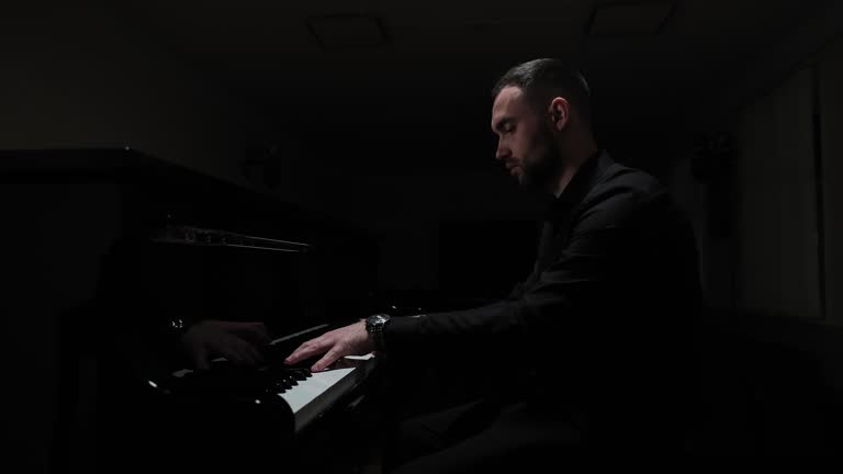 Playing the piano in a dark hall. Emotional piano playing