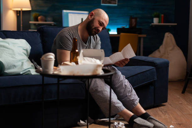 istock Anxious frustrated depressed young man reading letter 1491017434