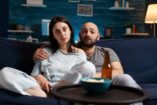 istock Confused astonished young couple watching documentary show 1491019700