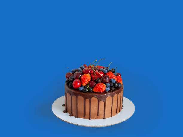 istock Chocolate cake with fresh berries, strawberry, cherry, blueberry isolated on blue background. Horizontal orientation 1491020868