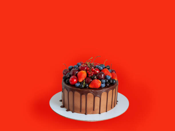 istock Chocolate cake with fresh berries, strawberry, cherry, blueberry isolated on red background. Horizontal orientation 1491020877