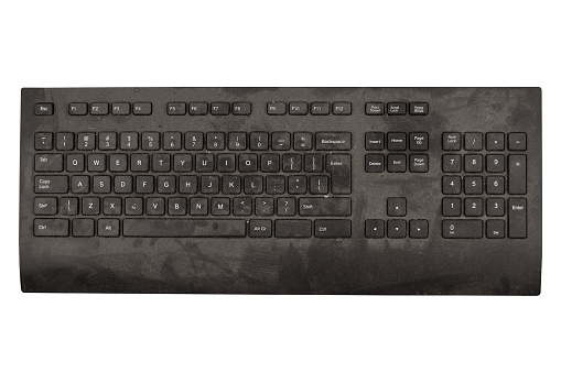 front view closeup of old black keyboard with keys covered in dust and dirt isolated on white background
