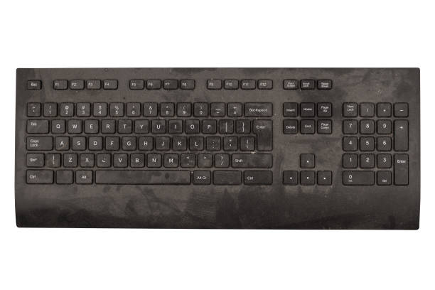 old black keyboard with keys covered in dust and dirt isolated on white background stock photo