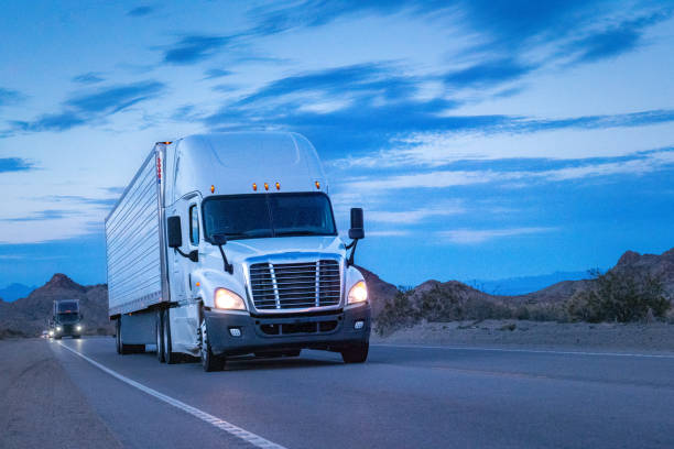 istock A white semi truck rolled through the Nevada Desert, its wheels kicking up dust as it journeyed on. Against the backdrop of majestic mountains, the sunset painted the sky in vibrant hues. 1491023151