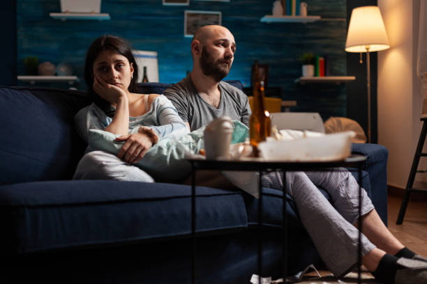istock Vulnerable, scared, depressed, frustrated young couple sitting on couch 1491023205