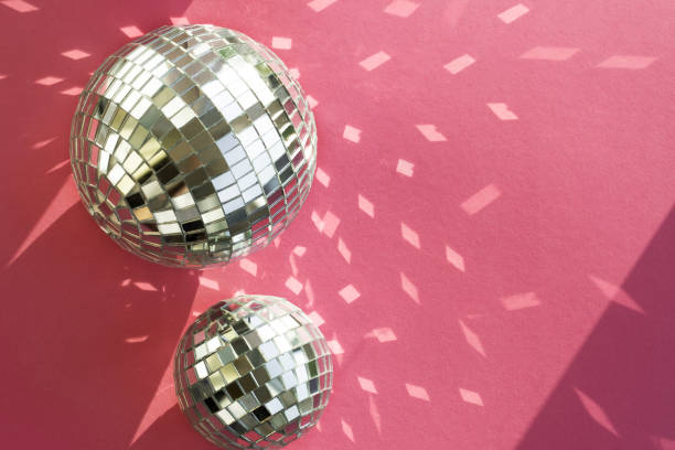 istock Disco ball on a pink background with shadows and highlights of bright sunlight. Abstract holiday background. 1491023295