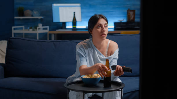 istock Woman using remote controller switching tv channels, searching funny film 1491028098