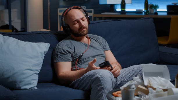 istock Helpless man with chronic depression putting on headset listening sad music 1491029413