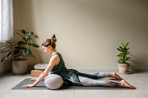 Professional woman practicing yoga at home: Cobra Pose, Bhujangasana