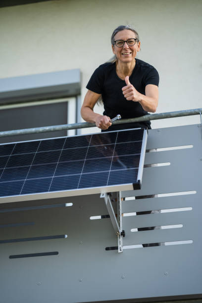 istock happy woman with solar panel on balcony 1491032701