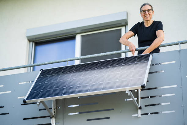 smiling woman mounting solar panel stock photo