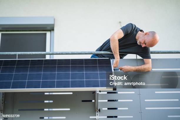 Man Mounting Solar Panel On Balcony Stock Photo - Download Image Now - Solar Panel, Balcony, Solar Energy
