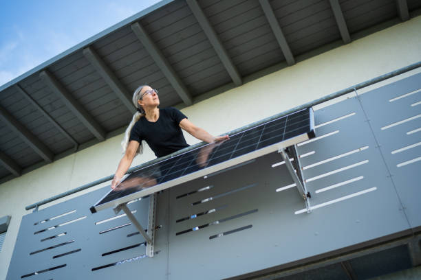 istock woman adjusting solar panel in direction of sunlight on her house balcony 1491032930