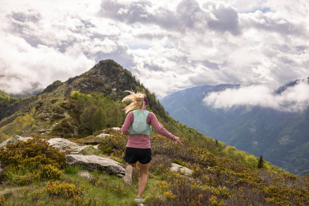 istock Female trail runner follows trail along mountain ridge 1491033808