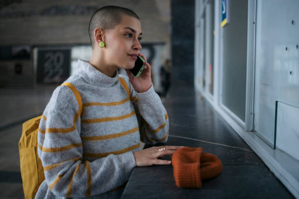 istock Female tourist using phone waiting for train at railway station 1491035470