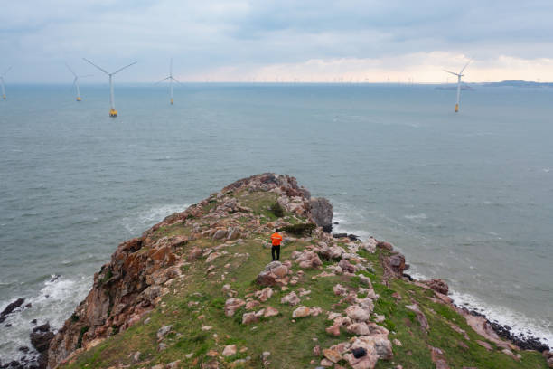 istock Power plant workers inspecting wind farm by the sea 1491038278