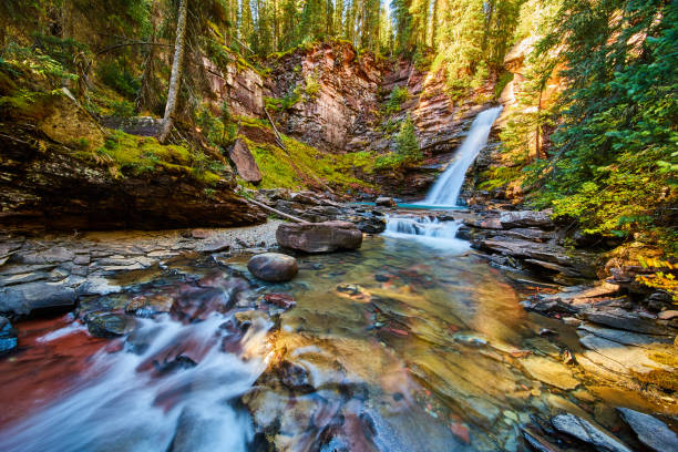 istock Peaceful and tranquil waterfall leading to shallow river in canyon with mossy rocks 1491041973
