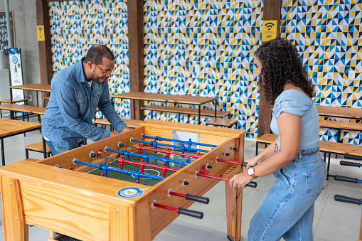 Coworkers playing in a foosball table