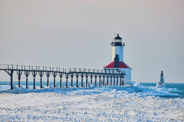 istock Red and white lighthouse on coast during winter 1491042785