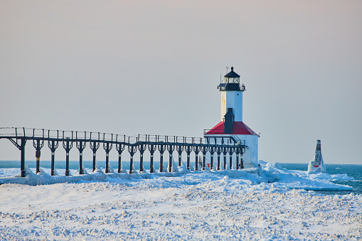 Image of Red and white lighthouse on coast during winter