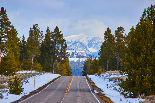 Image of Road in winter snow leading towards stunning mountain peaks