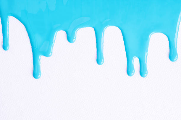 istock Light blue liquid drops of paint color flow down on white canvas. Blue paint dripping on the white wall with copy space. 1491043754
