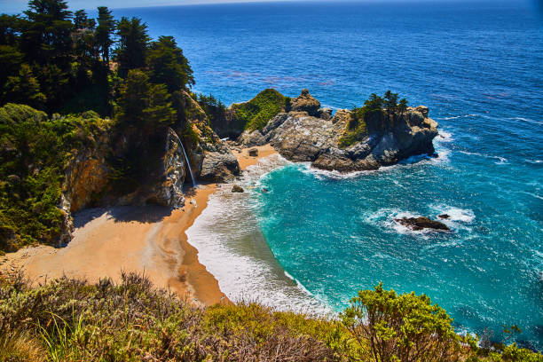istock Sandy beaches and coastal rocks surround hidden waterfall in this ocean cove 1491044413