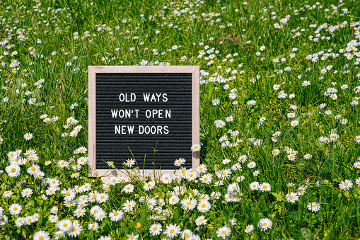 Old Ways Won't Open New Doors. Motivational quote on black letter board on pink background. Concept inspirational quote of the day. Greeting card, postcard